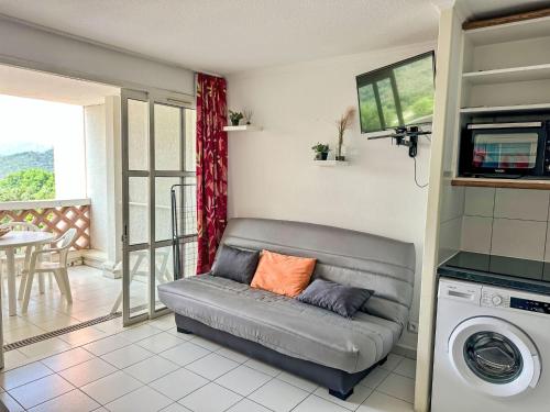 un salon avec un canapé et une machine à laver dans l'établissement Studio Le Village - C9 279 by Interhome, à Agay