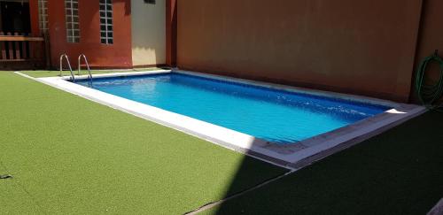a swimming pool with blue water in a building at Apartamentos Alcazar de Baeza in Baeza