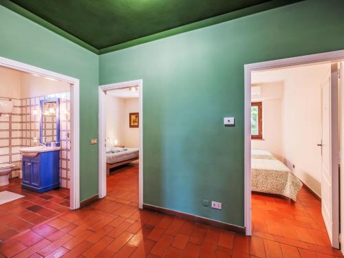 a room with green walls and a bed and a bathroom at Holiday Home I Tre Castagni by Interhome in Greppoleschieto