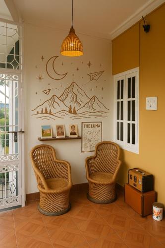 a room with two chairs and a wall at The Luna in Bīr