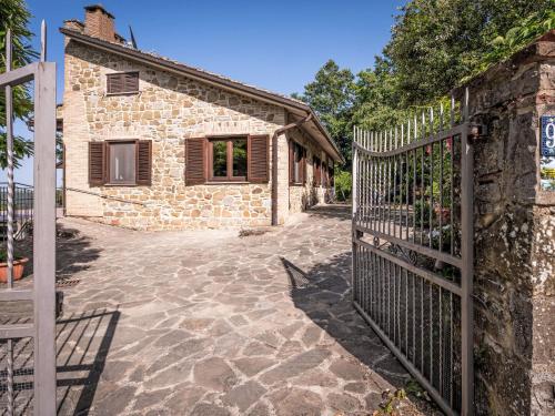 a gate in front of a stone building with a house at Holiday Home I Tre Castagni by Interhome in Greppoleschieto