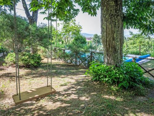 a swing in a park next to a tree at Holiday Home I Tre Castagni by Interhome in Greppoleschieto