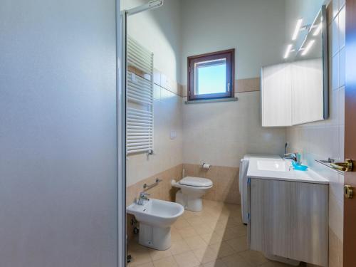 a bathroom with a toilet and a sink at Apartment Sughera by Interhome in Podere Dottrina