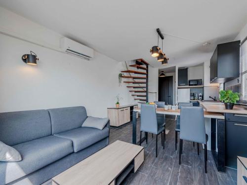 un salon avec un canapé bleu et une cuisine dans l'établissement Apartment Sombrero-1 by Interhome, au Barcarès