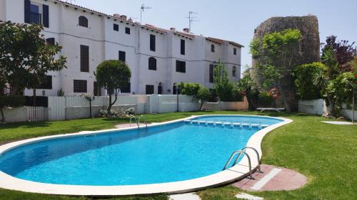 a swimming pool in a yard next to a building at Acogedor adosado con piscina in Torredembarra