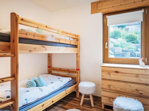 a bedroom with two bunk beds and a window at Chalet Le Souvenir by Interhome in Ovronnaz