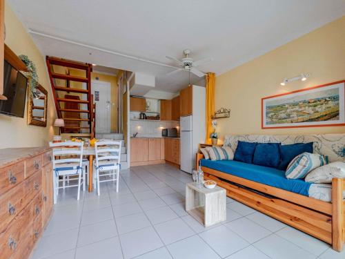 un salon avec un canapé bleu et une cuisine dans l'établissement Holiday Home Sombrero-4 by Interhome, au Barcarès