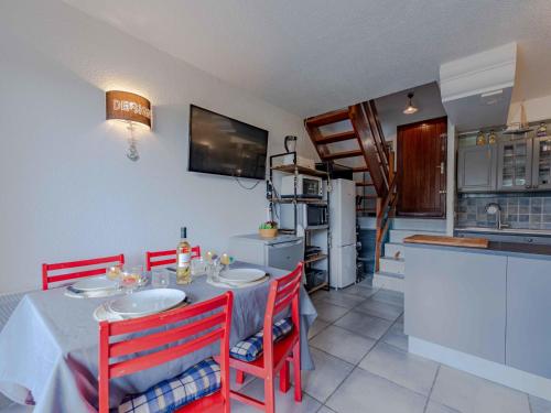 une cuisine avec une table et des chaises rouges dans l'établissement Holiday Home Sombrero-5 by Interhome, au Barcarès
