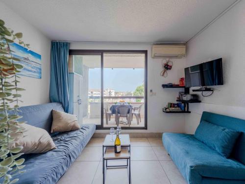 un salon avec un canapé bleu et une table dans l'établissement Apartment Coudalère-Les Hébrides-4 by Interhome, au Barcarès