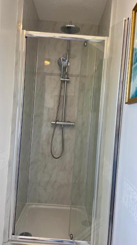 a shower with a glass door in a bathroom at Room with Newly Renovated Private Bathroom above Village Pub Stag Inn Crosby Maryport in Maryport