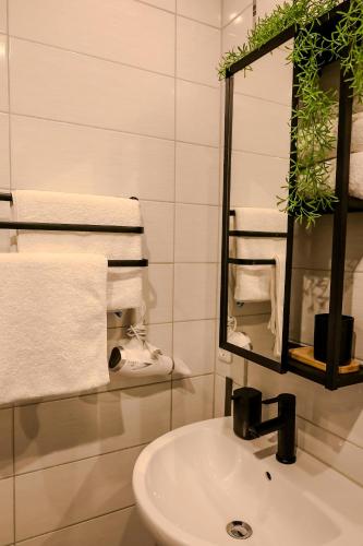 a bathroom with a sink and a mirror and towels at Pension Kastanie in Sehlen