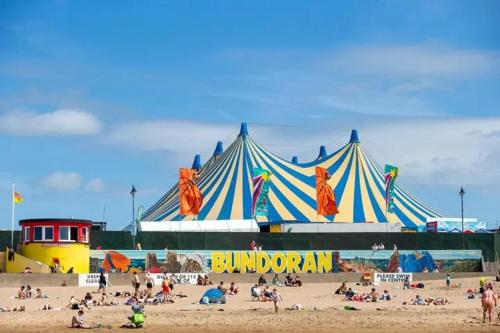 a circus tent on a beach with a crowd of people at Atlantic Point Stunning Sea View in Bundoran