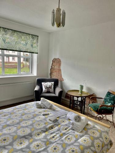 a bedroom with a bed and a chair and a table at Room with Newly Renovated Private Bathroom above Village Pub Stag Inn Crosby Maryport in Maryport