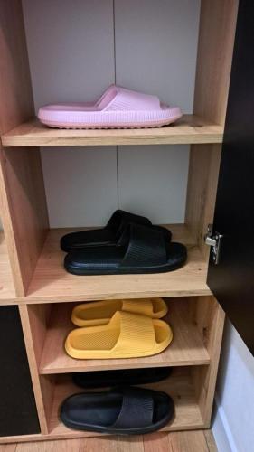 a wooden shelf with a pink lid and some shoes at Apartman 19 Vinkovci, klimatiziran, self check-in in Vinkovci
