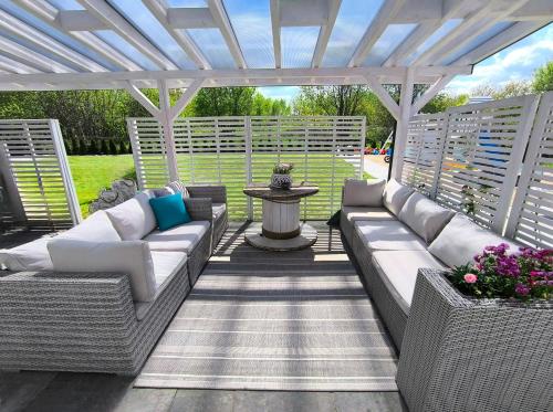 a patio with two couches and a pergola at Na Fali in Chłopy