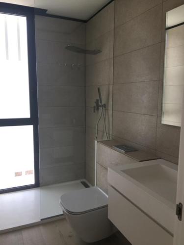 a bathroom with a toilet and a sink and a window at Casa de lujo en Gavá mar in Gavà