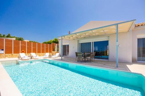a swimming pool in front of a house at Casa di Pietra in Lakithra