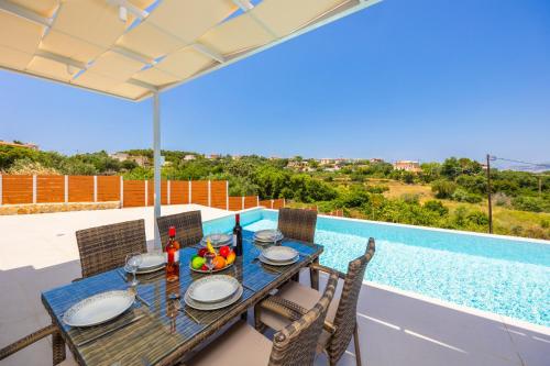 a table and chairs on a patio with a view of a pool at Casa di Pietra in Lakithra