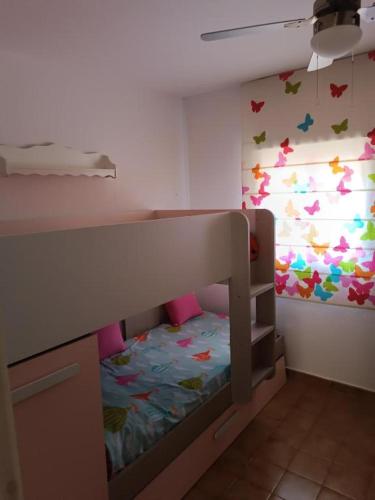 a small bedroom with a bunk bed with butterflies on the wall at Chalet calan Bosch Menorca in Cala'n Bosch