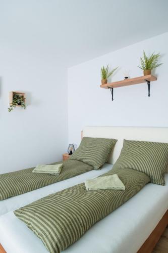 two beds sitting on top of a white wall at Harmónia Ház in Orfű