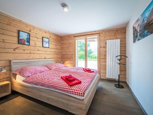 a bedroom with a bed with a red blanket at Chalet L'Eden by Interhome in Ovronnaz