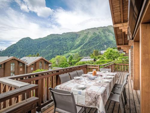 a wooden deck with a table and chairs on it at Chalet L'Eden by Interhome in Ovronnaz