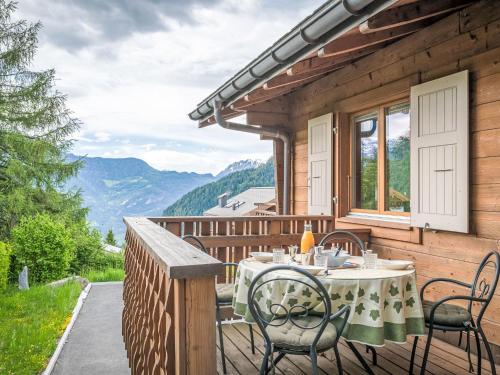 a wooden deck with a table and chairs on it at Chalet L'Eden by Interhome in Ovronnaz