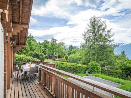 a wooden deck with a table and chairs on it at Chalet L'Eden by Interhome in Ovronnaz