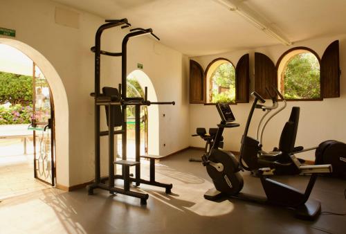 a gym with exercise bikes and ellipticals in a room at Hotel Don Diego in Porto San Paolo