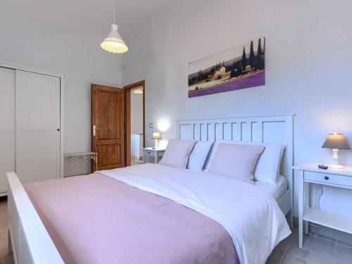 a white bedroom with a large white bed with white pillows at Holiday Home Villa Samanta by Interhome in Momjan