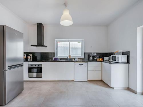 une cuisine blanche avec des armoires et des appareils blancs dans l'établissement Villa Villa dos Sonhos by Interhome, à Galé