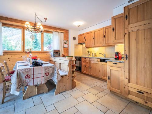 a kitchen with wooden cabinets and a table in it at Apartment Rhodos B101 by Interhome in Ovronnaz