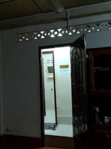 a mirror in a room with a kitchen and a refrigerator at Sakhone guesthouse in Ban Pho Touane