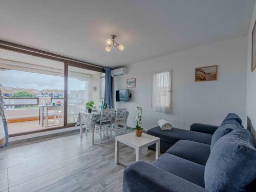 un salon avec un canapé bleu et une table dans l'établissement Apartment Saba by Interhome, au Barcarès