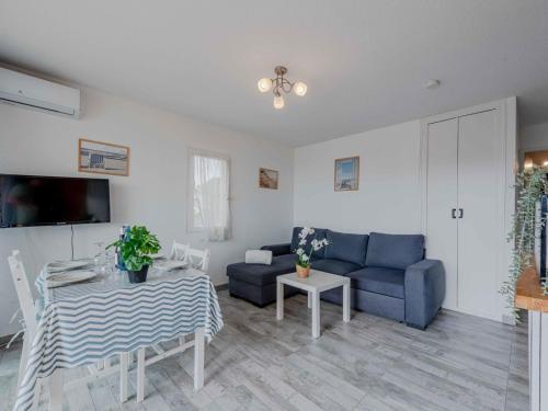 un salon avec un canapé bleu et une table dans l'établissement Apartment Saba by Interhome, au Barcarès