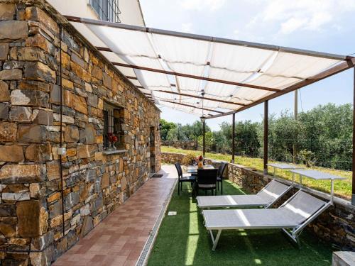 a stone walled patio with a table and chairs at Apartment Rose by Interhome in Civezza