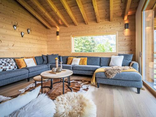 a living room with blue couches and a table at Chalet La Luna by Interhome in Ovronnaz