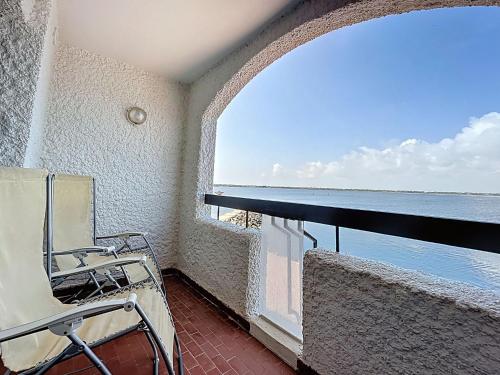 un balcon avec une chaise et une vue sur l'océan dans l'établissement Apartment Coudalère-Guadeloupe-15 by Interhome, au Barcarès