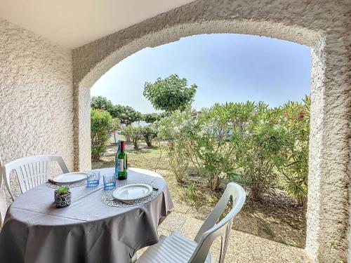 - une table avec une bouteille de vin sur la terrasse dans l'établissement Apartment Coudalère-Guadeloupe-14 by Interhome, au Barcarès
