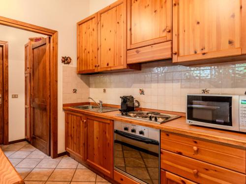 a kitchen with wooden cabinets and a stove top oven at Apartment Deliziosa Mansarda by Interhome in Ponte di Legno