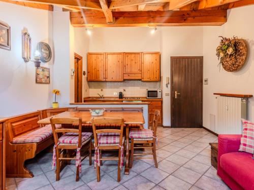 a kitchen and dining room with a wooden table and chairs at Apartment Deliziosa Mansarda by Interhome in Ponte di Legno