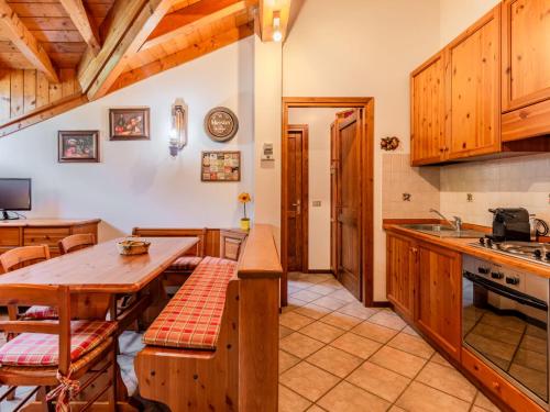 a kitchen with wooden cabinets and a wooden table at Apartment Deliziosa Mansarda by Interhome in Ponte di Legno