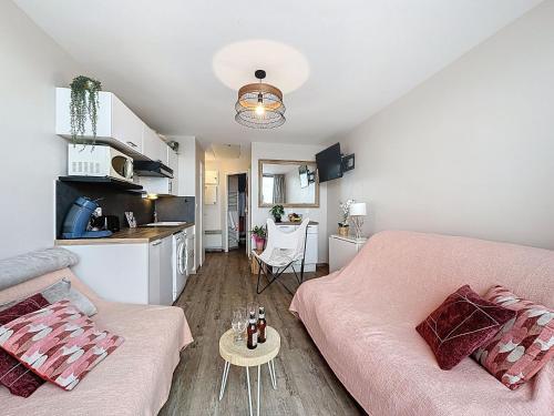 un salon avec un canapé rose et une cuisine dans l'établissement Apartment Les Marquises-4 by Interhome, au Barcarès