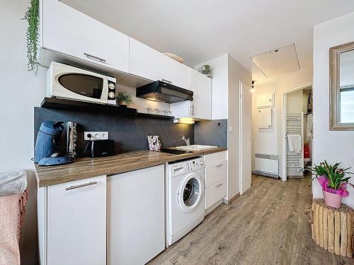 une cuisine avec des armoires blanches et une laveuse et une sécheuse dans l'établissement Apartment Les Marquises-4 by Interhome, au Barcarès