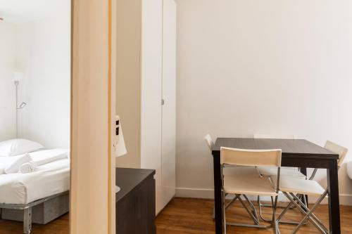 - une chambre avec un bureau, un lit, une table et des chaises dans l'établissement Pied-a-terre near Bastille & Voltaire Paris 11th, à Paris