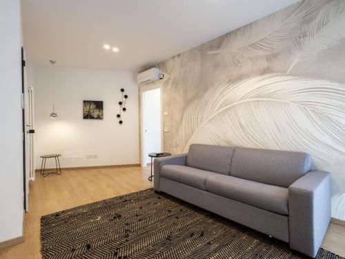 a living room with a couch and a wall with a mural at Apartment Marconi by Interhome in Chiavenna