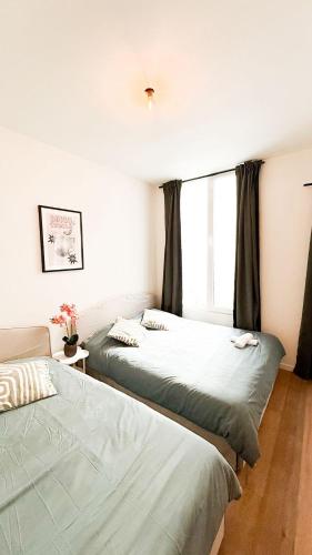 two beds in a room with a window at Stylish Home on the Waterfront Near Antwerp Historic Center in Antwerp