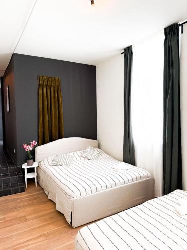 two beds in a bedroom with black walls at Stylish Home on the Waterfront Near Antwerp Historic Center in Antwerp