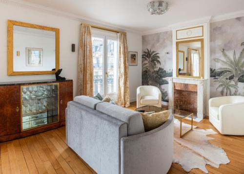 un salon avec un canapé et une cheminée dans l'établissement Captivating 2BD Flat Jules Joffrin Mairie du 18, à Paris