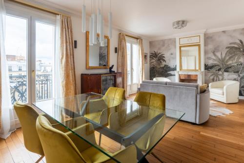 une salle à manger avec une table en verre et des chaises jaunes dans l'établissement Captivating 2BD Flat Jules Joffrin Mairie du 18, à Paris